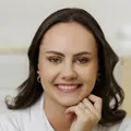Dra. Larissa Basmage de jaleco branco, sorrindo